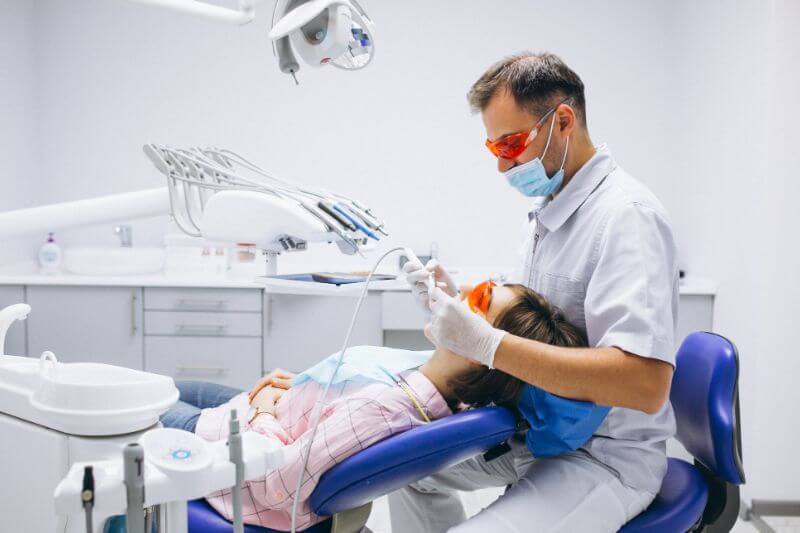 Dentista fazendo clareamento em paciente