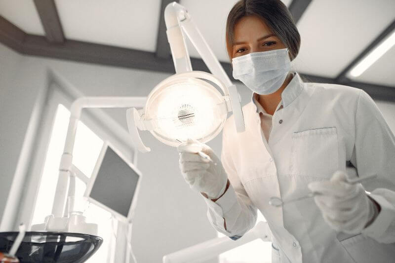 Dentista segurando um refletor odontológico