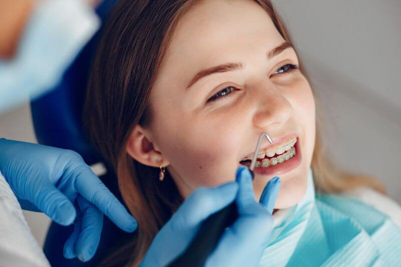 Dentista ajustando aparelho de uma paciente