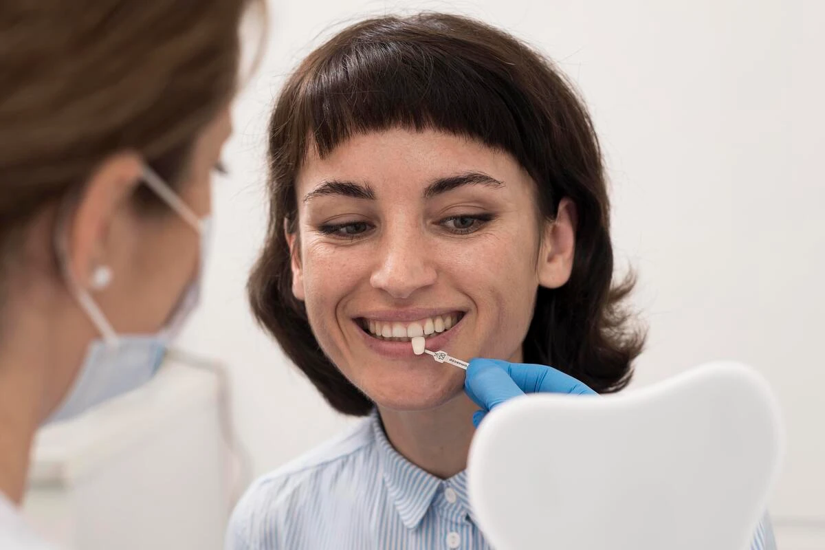 Lentes de contato dental: entenda as vantagens clínicas e estéticas Paciente e dentista analisando aplicação de lentes de contato dental por profissional de odontologia em clínica especializada.