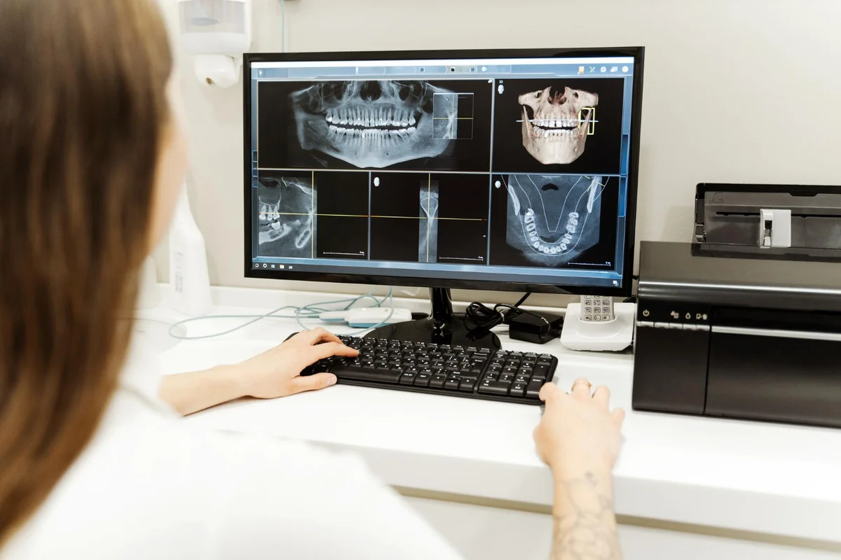 Dentista analisando radiografias dentárias no computador