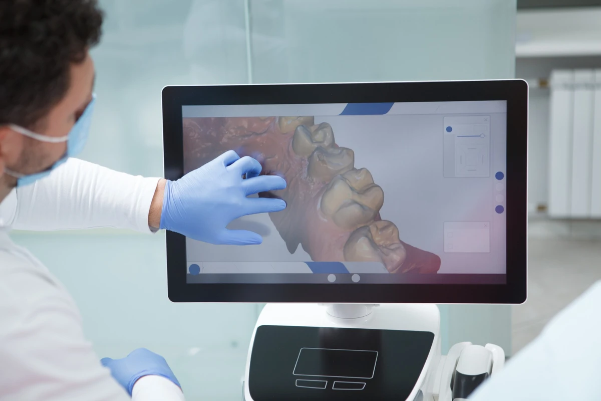 Dentista usando scanner digital para criar modelo 3D dos dentes de um paciente.