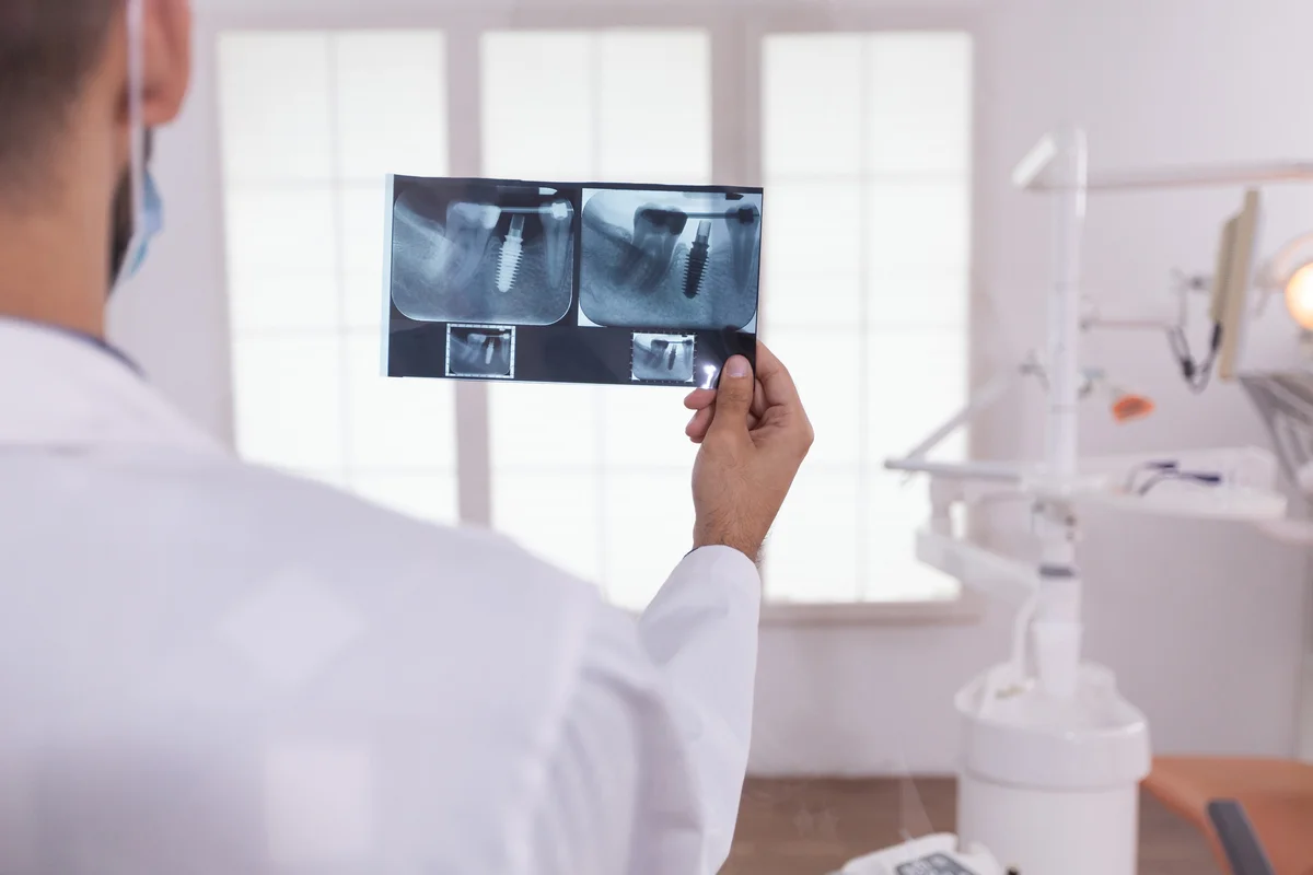 Dentista segurando e analisando radiografia