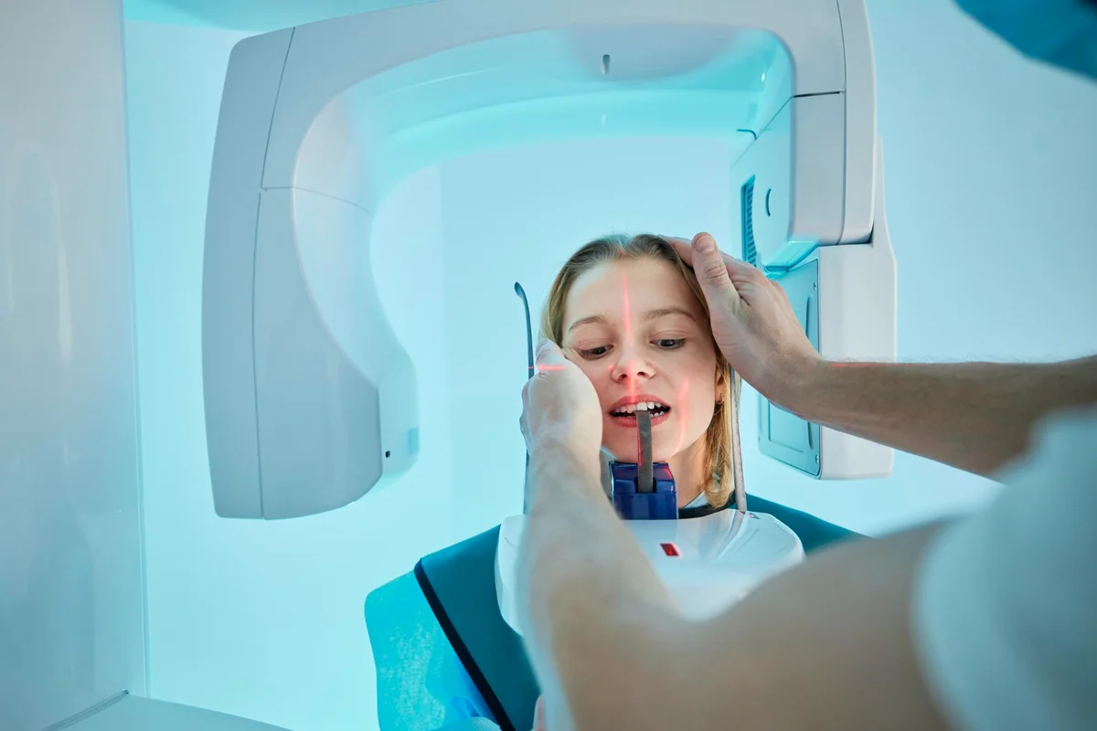 Paciente feminina passando por exame de radiografia dental com equipamento moderno em clínica odontológica