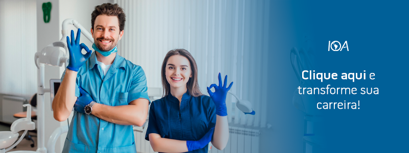 Dentista e assistente sorrindo e fazendo sinal de ok em clínica odontológica